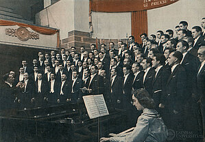 Koncerts LVU Lielajā aulā. Diriģē Haralds Mednis, attēla centrā - operas solists Pēteris Grāvelis, pie klavierēm - koncertmeistare Maija Saiva. 1954. gads. Foto: Jāzepa Vītola Latvijas Mūzikas akadēmijas bibliotēkas krājuma